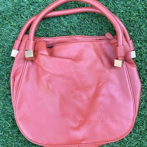 Miu Miu coral orange leather hobo bag. Brushed gold metal details.